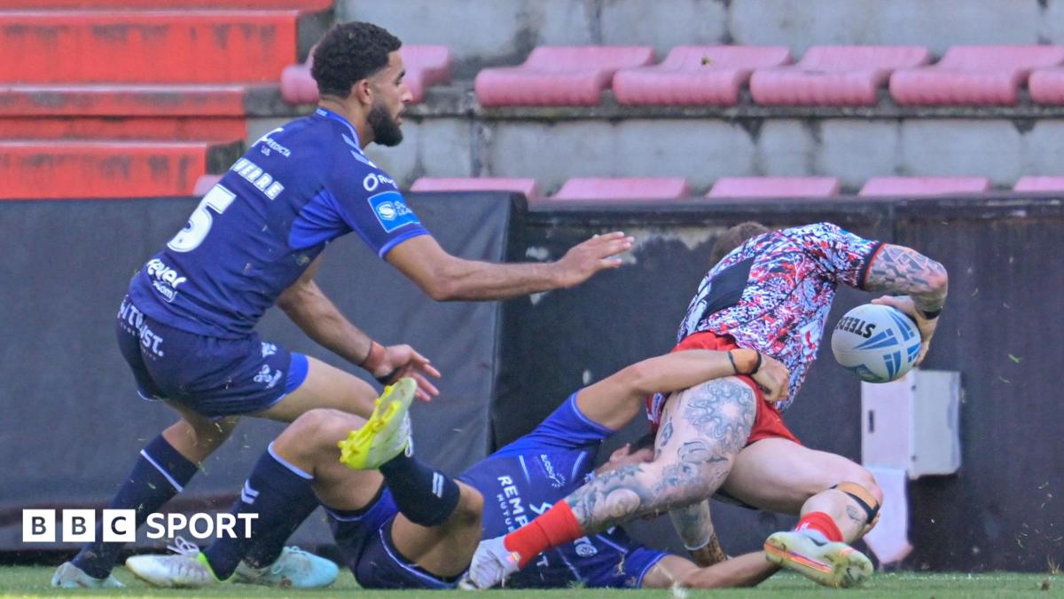 Josh Charnley (CHARNLEY 5) about to score a try on the right with two Toulouse players, one on the floor and one bending down, not being able to stop him