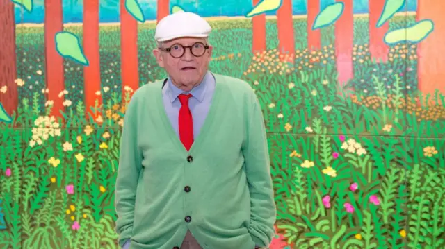 David Hockney poses with one of his paintings in Paris in 2017