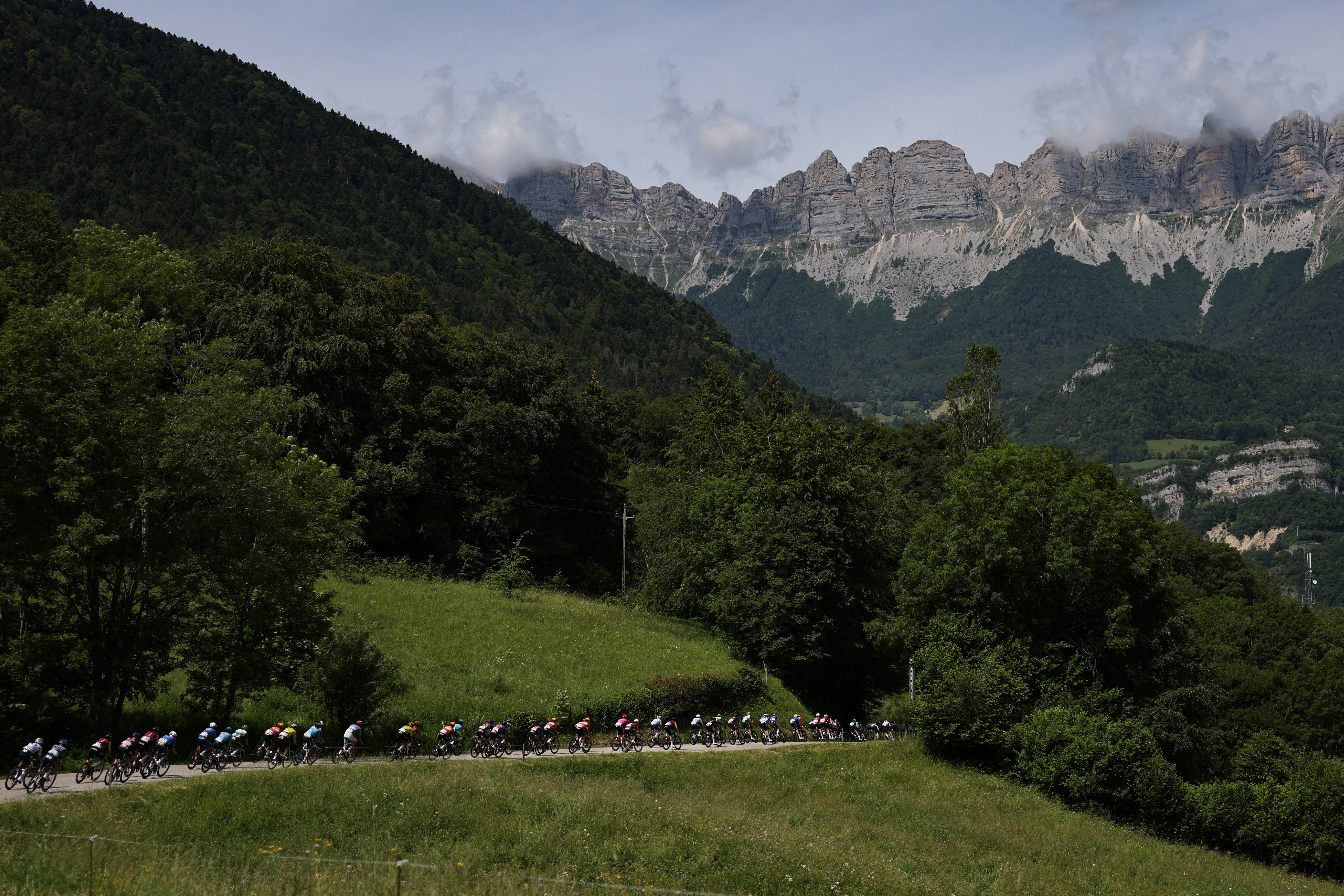 The pack of riders (peloton) cycles during the 1st stage of the Tour Auvergne-Rhone-Alpes cycling race (formerly known as the Criterium du Dauphine), 146,2km between Vizille and Saint-Ismier, in the French Alps, on June 7, 2026. (Photo by Anne-Christine POUJOULAT / AFP)