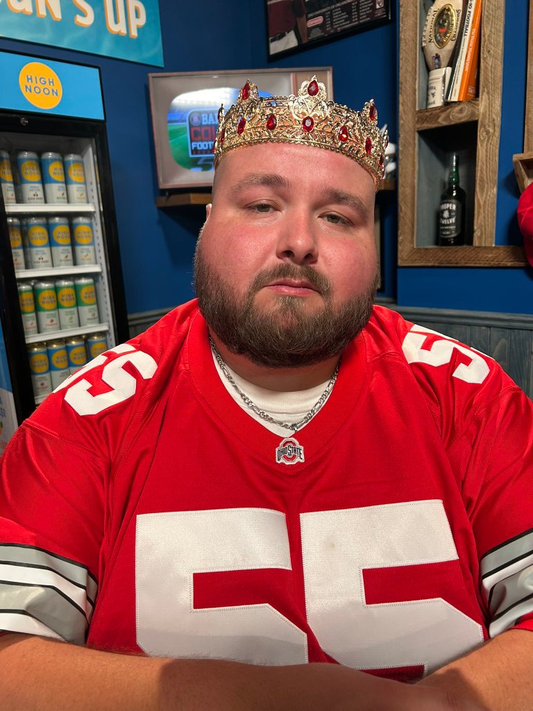 Barstool Sports personality Big Ev wearing a red Ohio State jersey and a gold crown with red jewels.