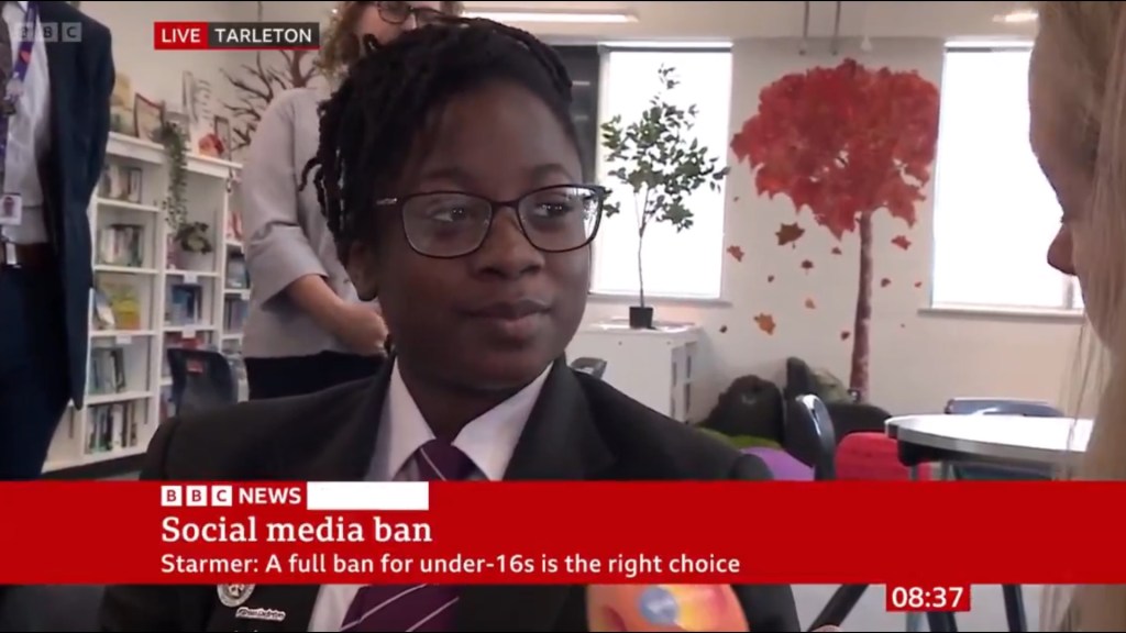 A British student, with glasses and braided hair, looks slightly to the right, with a BBC News banner at the bottom announcing "Social media ban."