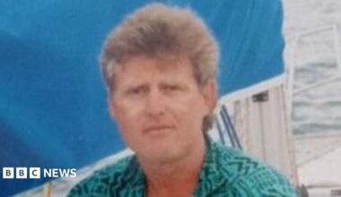 Farmer Thomas Olverson wearing a green shirt, sitting on a yacht on a body of water