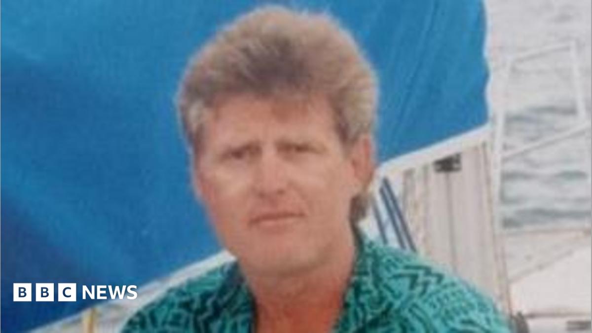 Farmer Thomas Olverson wearing a green shirt, sitting on a yacht on a body of water