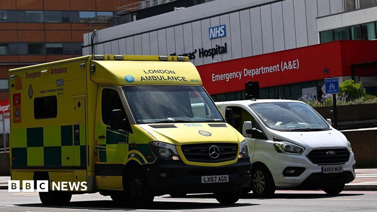 Yellow London Ambulance Service ambulance parked outside an NHS hospital emergency department (A&E).