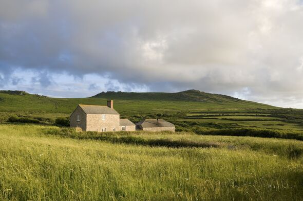 Country farm house in a grassy field near moorland Country farm house in a grassy field near moorland