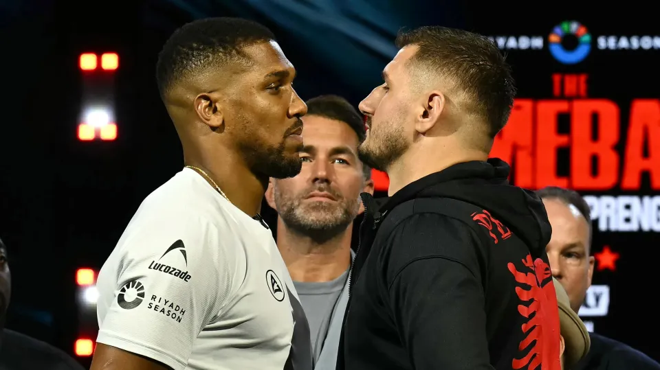 Promoter Eddie Hearn (C) stares as Albania's Kristian Prenga (R) and Britain's Anthony Joshua (L) pose together at a press conference in London on June 1, 2026, ahead of their boxing match in Saudi Arabia in July