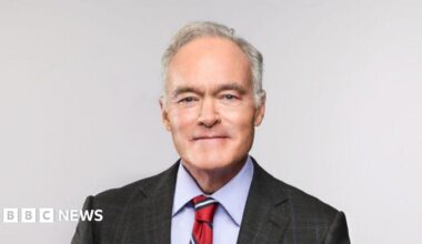Scott Pelley sits in a chair posing for a portrait