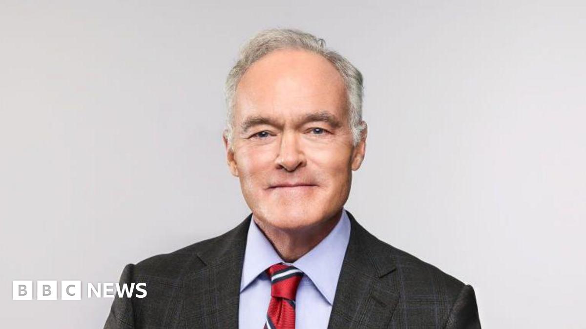 Scott Pelley sits in a chair posing for a portrait