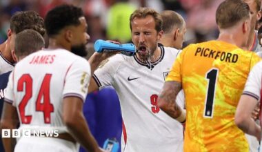 Harry Kane squirts water on his face during a hydration break in England's match against Croatia at the 2026 World Cup.