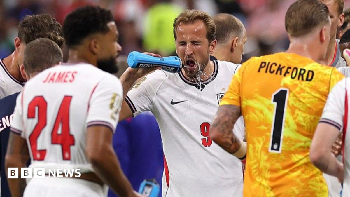Harry Kane squirts water on his face during a hydration break in England's match against Croatia at the 2026 World Cup.