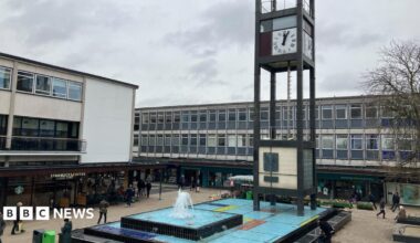 A view of Stevenage town centre showing the clock tower and water feature surrounded by shops