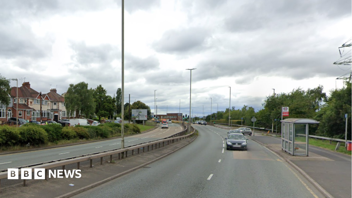 Image shows a dual carriageway, with houses on the left handside and cars travelling down the right hand side