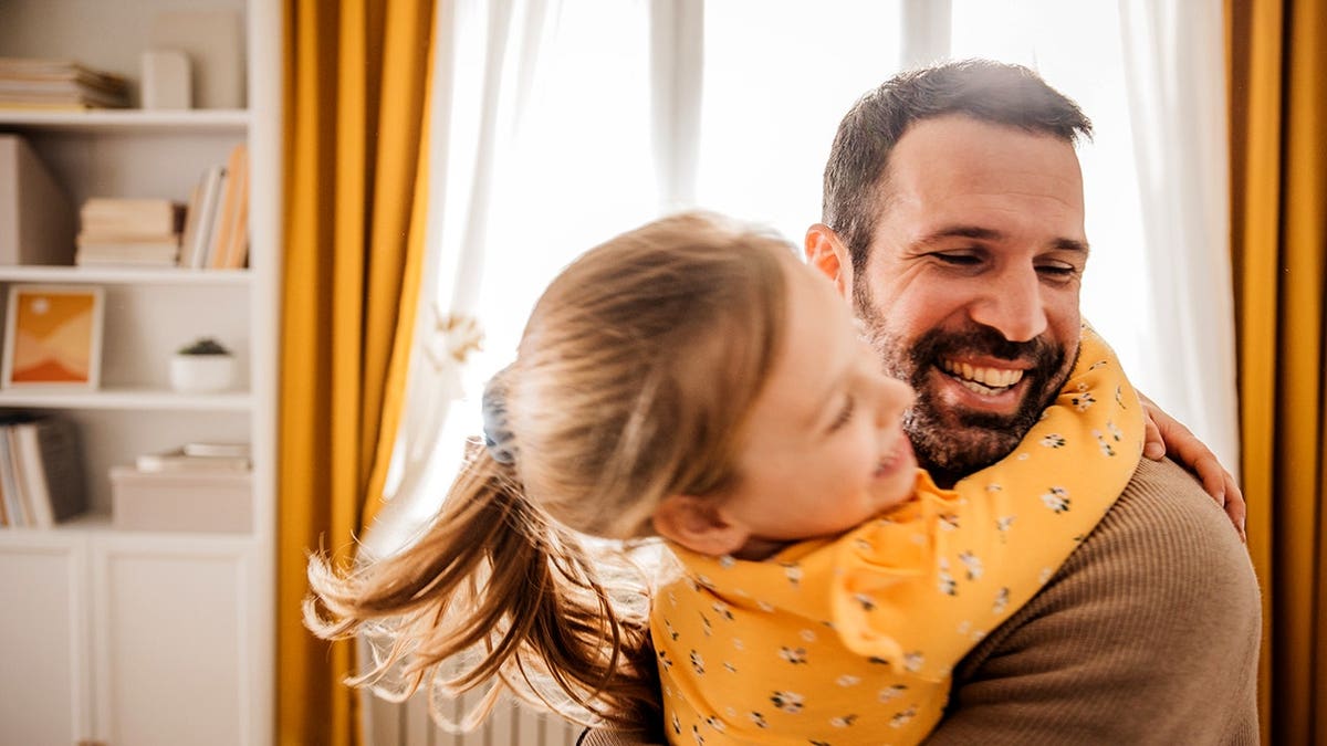 A dad sitting with his daughter enjoying time at home
