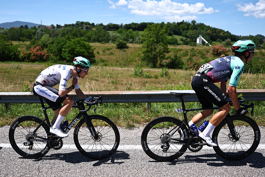 Decathlon CMA CGM Team's French rider Paul Seixas (L) wearing the best young rider's white jersey cycles, bearing visible injuries following a crash, during the 7th stage of the Tour Auvergne-Rhone-Alpes cycling race (formerly known as the Criterium du Dauphine), 133,6km between La Bridoire and Grand Colombier in the French Alps on June 13, 2026. (Photo by Anne-Christine POUJOULAT / AFP)