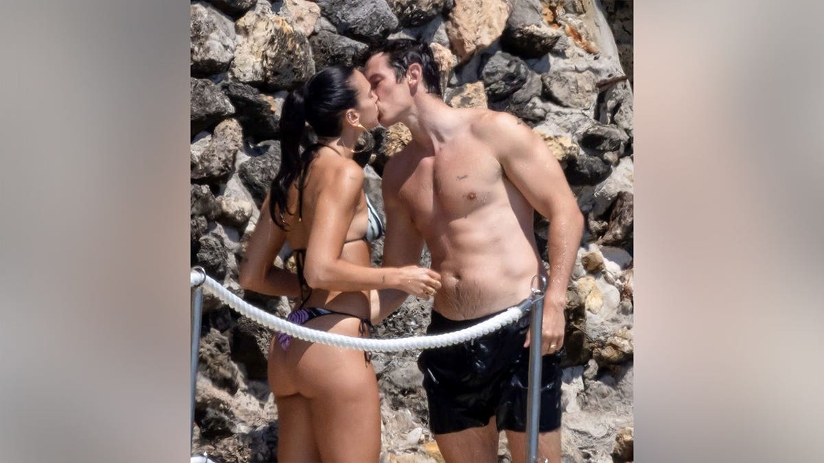 Dua Lipa and Callum Turner kissing while in their bathing suits in Italy in June 2026.