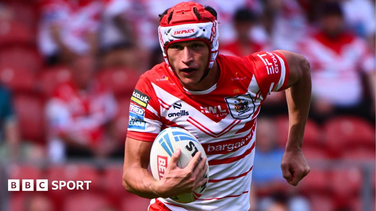 Harry Robertson, wearing St Helens' red and white jersey, runs with a rugby league ball in his right hand