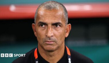 Close up of Sabri Lamouchi standing in the dugout looking focused