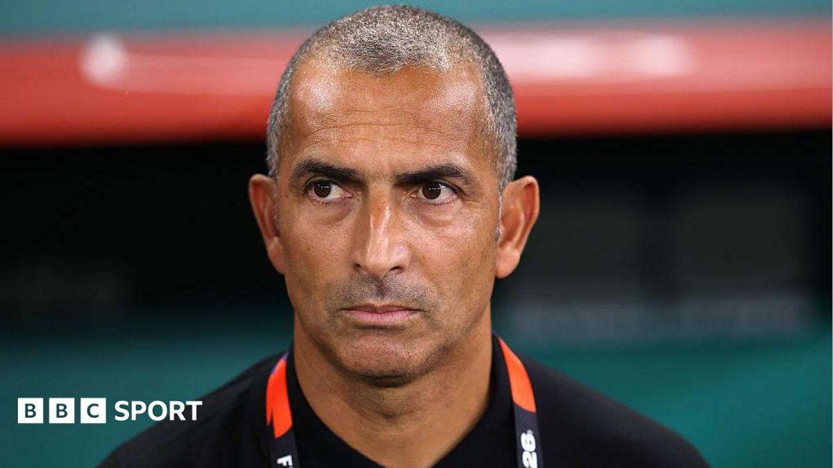 Close up of Sabri Lamouchi standing in the dugout looking focused
