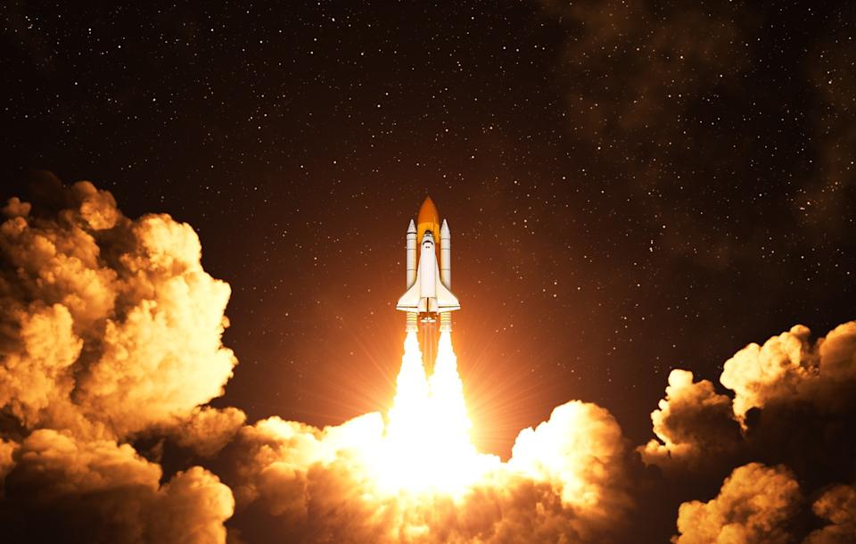 Spaceship launching into orbit on a starry night.