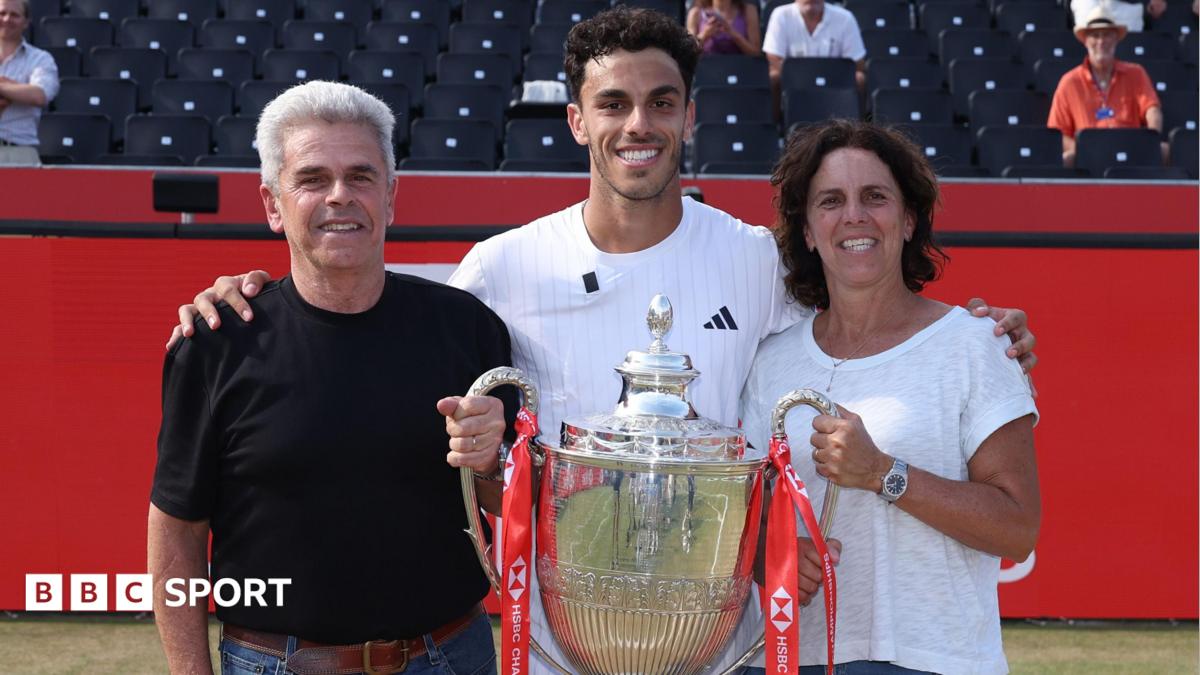 Francisco Cerundolo poses with the Queen's trophy alongside his parents