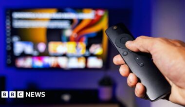 TV remote pointed at TV with streaming services
