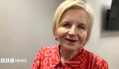Donna Ockenden looks into camera. She is wearing a patterned red blouse and has short blonde hair.