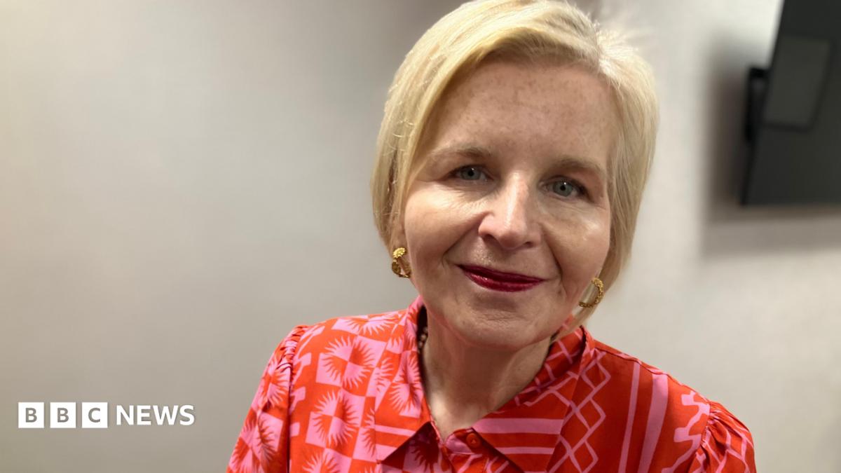 Donna Ockenden looks into camera. She is wearing a patterned red blouse and has short blonde hair.
