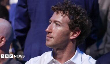 Mark Zuckerberg, wearing a white collared shirt while sitting in a crowd at the recent UFC event at the White House.