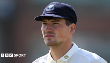 Henry Crocombe looks on, while wearing a blue cap