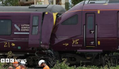 The ends of two damaged purple trains which have crashed together.