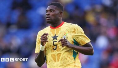 Thomas Partey running, wearing a yellow patterned Ghana shirt