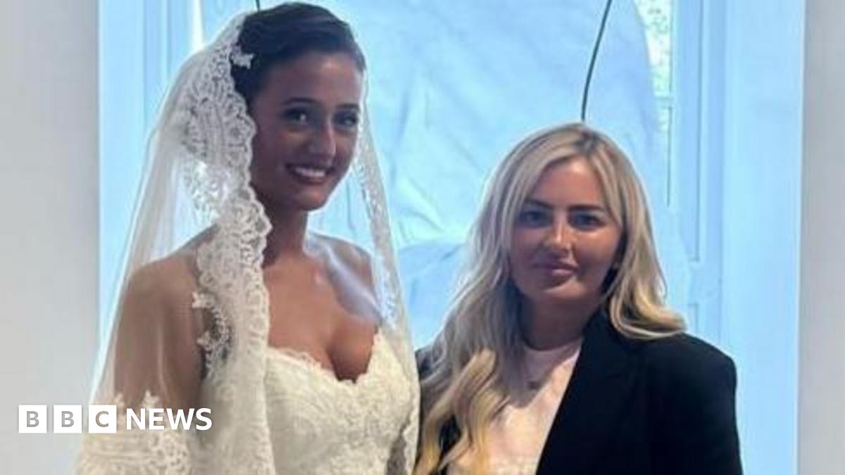 Venezuela Fury in a wedding dress stood next to Lynsey Austin. She is wearing a black jacket and a pink top underneath it.