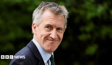 Dan Jarvis is wearing a dark blue suit jacket, a light blue shirt and a dark blue tie.