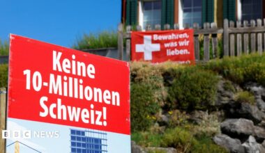Signs stand in front of a building, on the day of the vote on a plan backed by the right-wing Swiss People's Party (SVP)