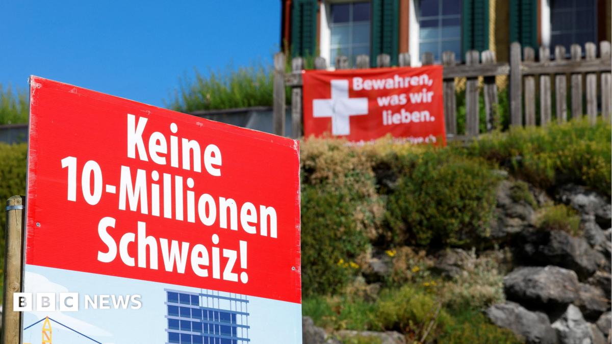 Signs stand in front of a building, on the day of the vote on a plan backed by the right-wing Swiss People's Party (SVP)