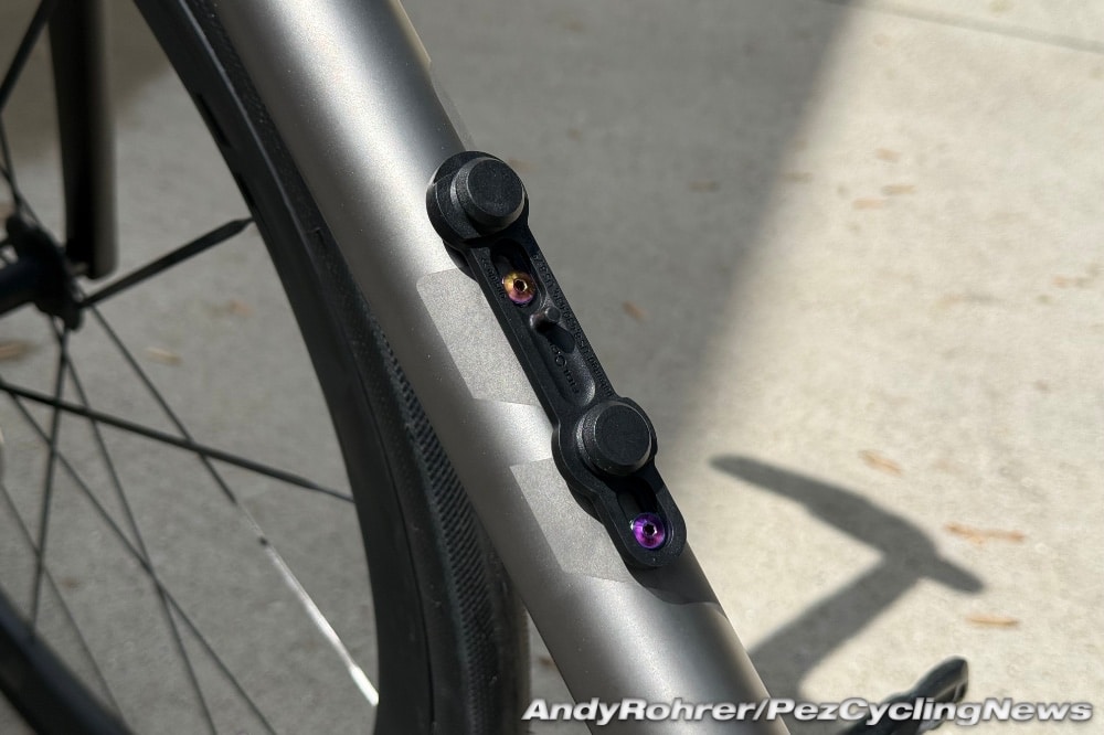 The Fidlock Twist system relies on a low-profile magnetic base directly attached to the frame. This base provides tabs for the lock gates to grip onto when a bottle is placed on it. The base is securely attached to the frame using screws with low-profile heads to prevent interference with the bottle connector.