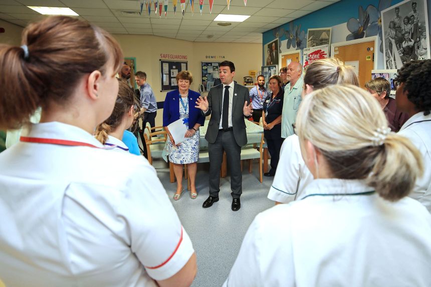 Andy Burnham pictured talking to staff at a hospital in 2018.