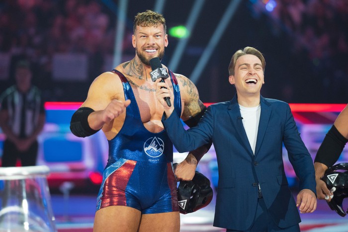 gladiators-giant-barney-walsh Giant and Barney Walsh. Barney is holding a microphone and is laughing while Giant is smiling