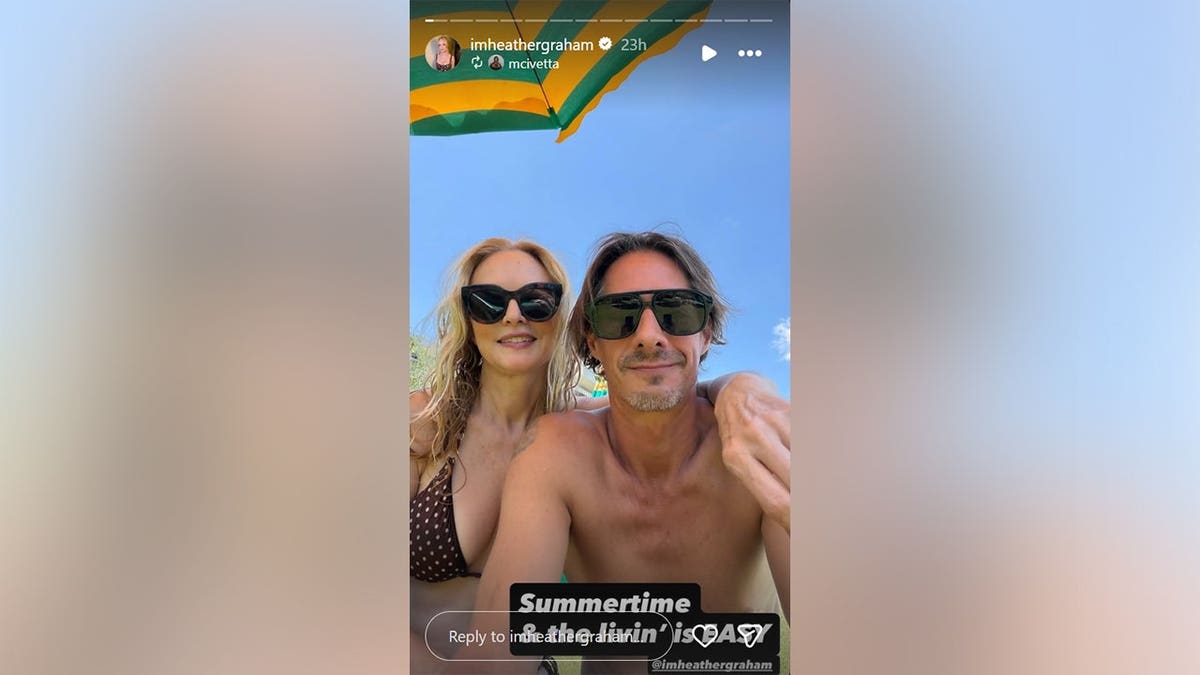 Heather Graham and her boyfriend in swimsuits together at the beach.