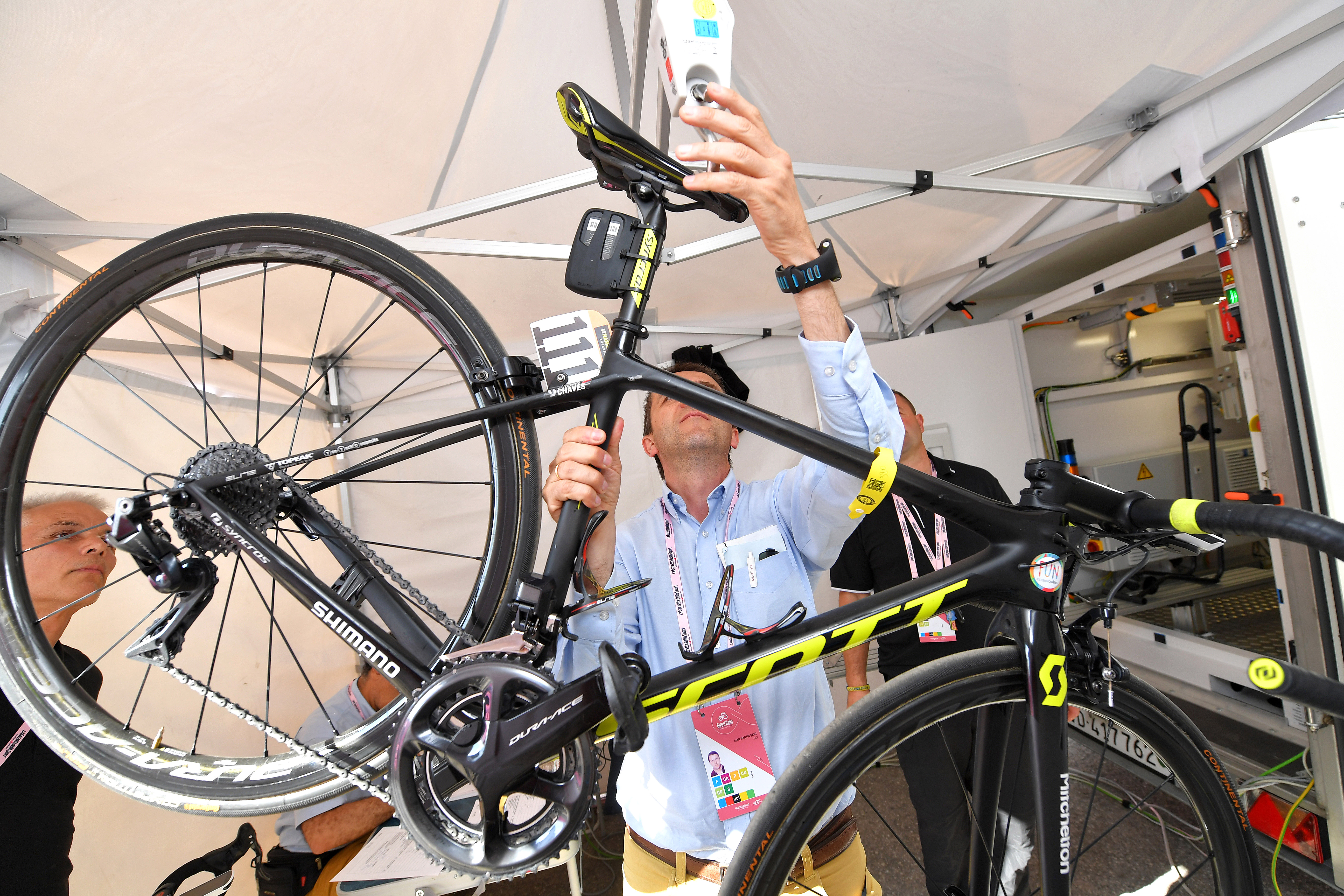 A UCI official weighs a bike ahead of putting it in the UCI X-Ray machine during the 101st Tour of Italy 2018