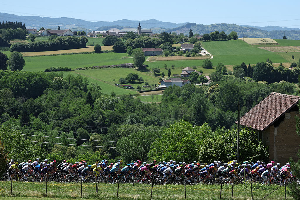 The pack of riders (peloton) cycles during the 7th stage of the Tour Auvergne-Rhone-Alpes cycling race (formerly known as the Criterium du Dauphine), 133,6km between La Bridoire and Grand Colombier in the French Alps on June 13, 2026. (Photo by Anne-Christine POUJOULAT / AFP)
