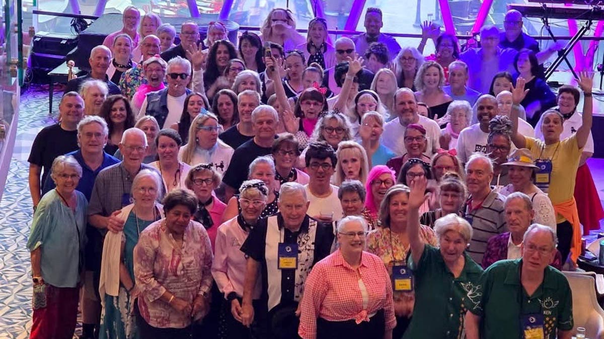 A group of people pose for a photo on a cruise ship.