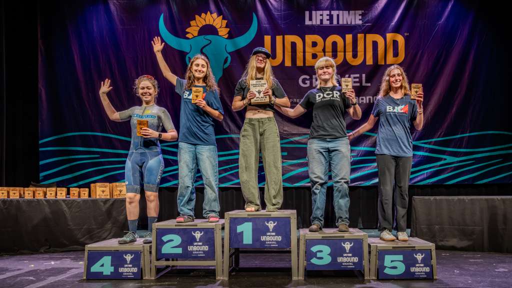 U23 rider Kylee Hanel stands on top step of podium for winning 2026 Unbound Gravel 100