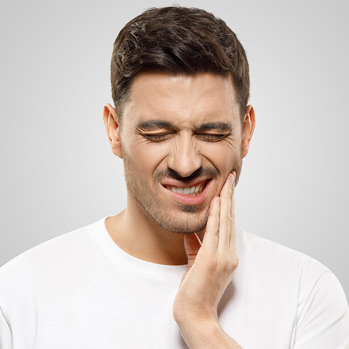 Man in pain holding jaw indicative of jaw transformation Man in pain holding jaw indicative of jaw transformation