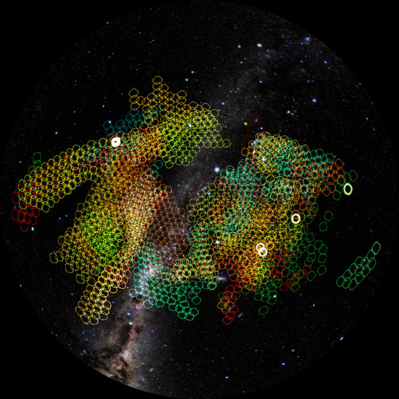 A starry night sky overlaid with clusters of colored circles—yellow, red, green, and orange—forming complex patterns that highlight mapped regions against the backdrop of the Milky Way.