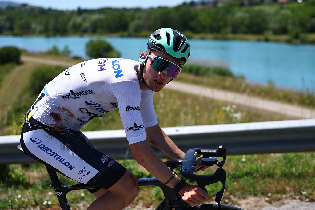 Decathlon CMA CGM Team's French rider Paul Seixas wearing the best young rider's white jersey cycles, bearing visible injuries following a crash, during the 7th stage of the Tour Auvergne-Rhone-Alpes cycling race (formerly known as the Criterium du Dauphine), 133,6km between La Bridoire and Grand Colombier in the French Alps on June 13, 2026. (Photo by Anne-Christine POUJOULAT / AFP)