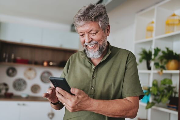 Senior man using smartphone at home Senior man using smartphone at home