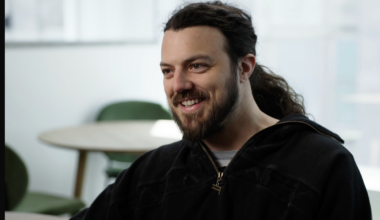 A caucasian man with long dark hair and a full beard