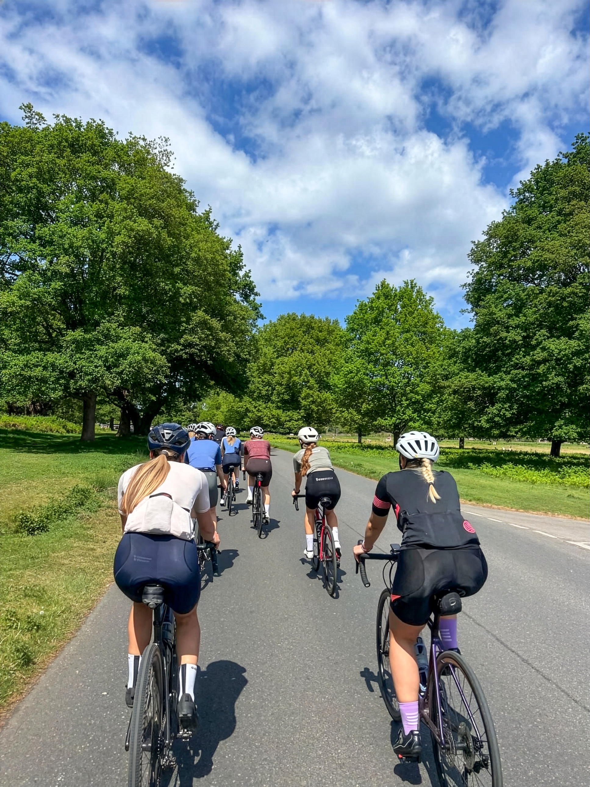 A group of female riders riding through parkland