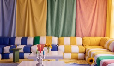 a room draped in colorful fabric with multicolor striped sofas and fabric on the floor